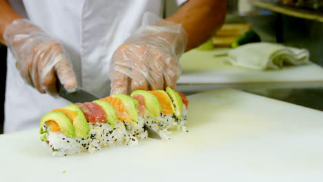 chef masculino cortando sushi en la cocina 4k