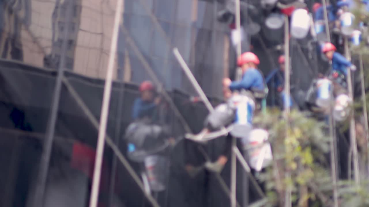 높은 건물 의 창문 을 수리 하는 노동자 들 의 팀