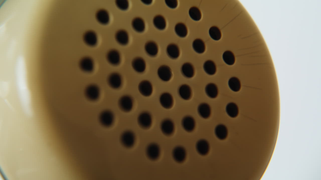 Phone cord stretching spiral to retro receiver closeup. Coiled telephone cable