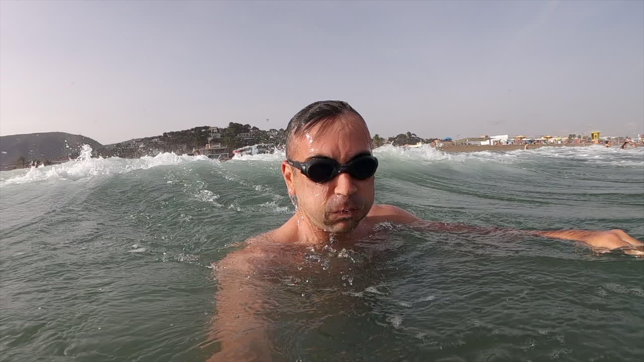 Man wearing swimming googles swimming in the sea