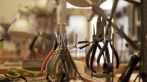 close-up of workroom full of pliers, tweezers, splitters and other tools