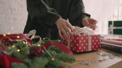 envolver regalo de navidad. mujer envuelve el regalo con decoración navideña ecológica y se prepara para la temporada navideña.