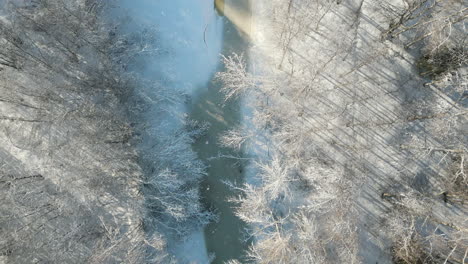 Zauberhafte-Schneebedeckte-Weiße-Winterlandschaft,-Vogelperspektive-Auf-Den-Gefrorenen-Bach