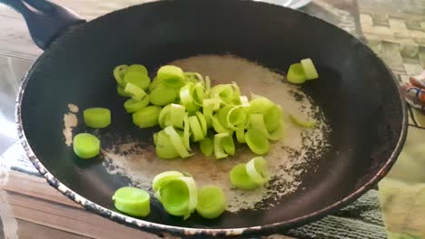 slow motion of sliced young onions in the frying pan