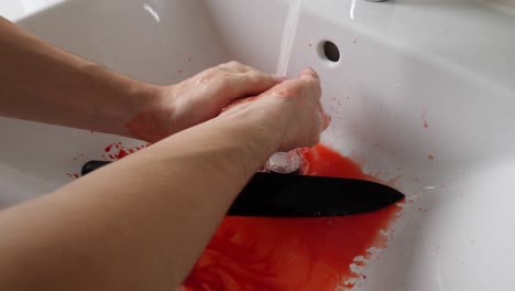 the psychopath killer calmly washing the blood from his hands after murdering the victim with a knife