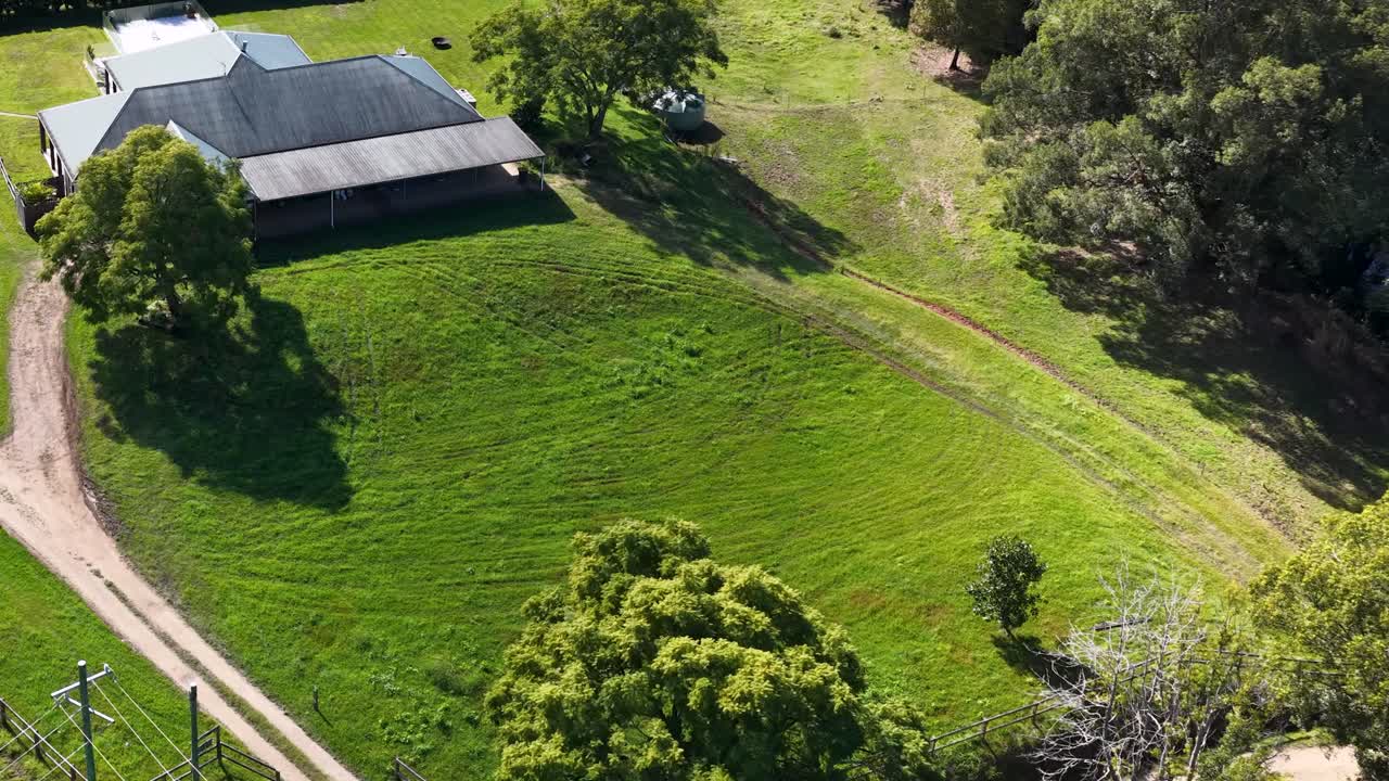 Aerial footage of a rural property in Uki, NSW, showcasing green fields and a house under bright daylight