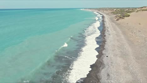 Waves-hitting-the-coast-of-Dunas-de-las-Calderas-National-Monument-in-Dominican-Republic---descending,-aerial-view