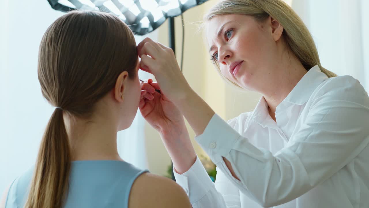 artista de maquillaje aplicando maquillaje a un modelo en un estudio