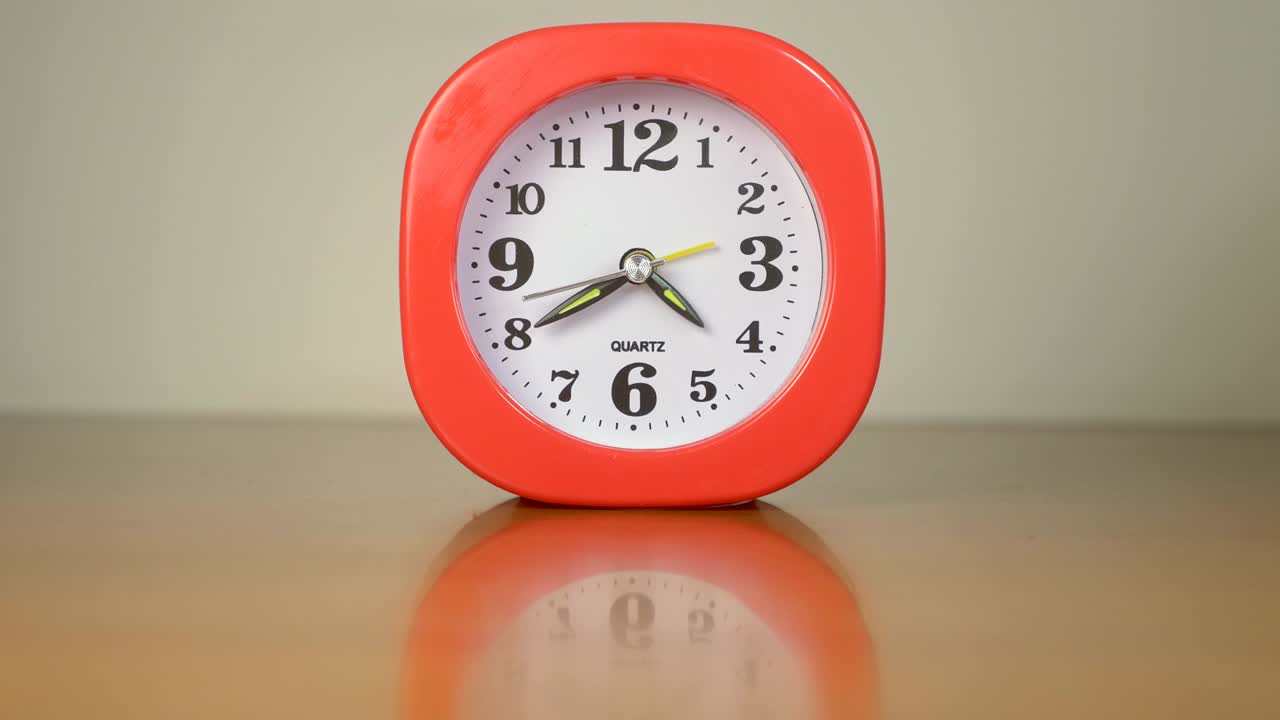 테이블 위에 있는 작은 빨간 시계는 시간을 때리고 있습니다. 시간, 서두르기 - 시간 지연