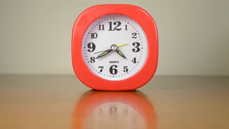 pequeño reloj rojo en la mesa batiendo el tiempo. tiempo, prisa - lapso de tiempo