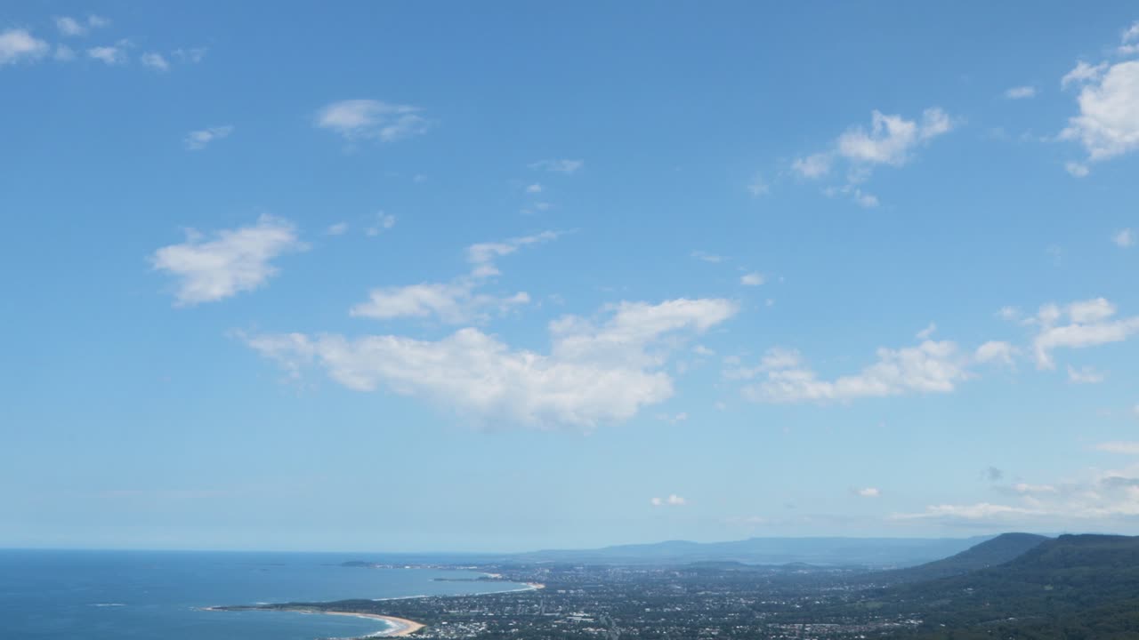 은 날에 일라와라 남쪽 해안의 광활한 도시 풍경을 드러내기 위해 아래로 기울어집니다.