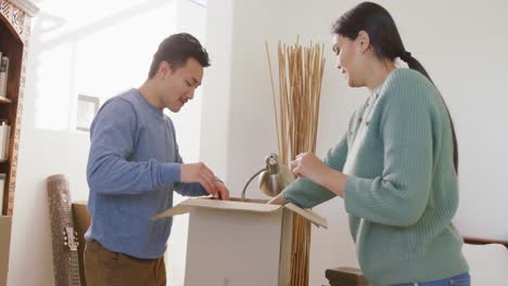 video de una feliz pareja diversa desempaquetando cajas después de mudarse