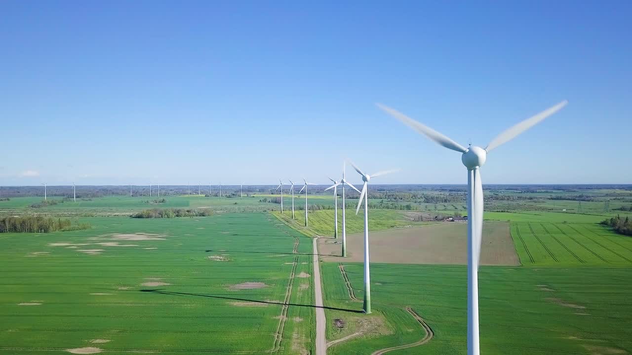 바람 농장에서 재생 가능한 에너지를 생성하는 풍력 터빈의 공중 전망, 화창한 봄날, 녹색 농경지, 시골 도로, 광각 드론 샷 앞으로 이동