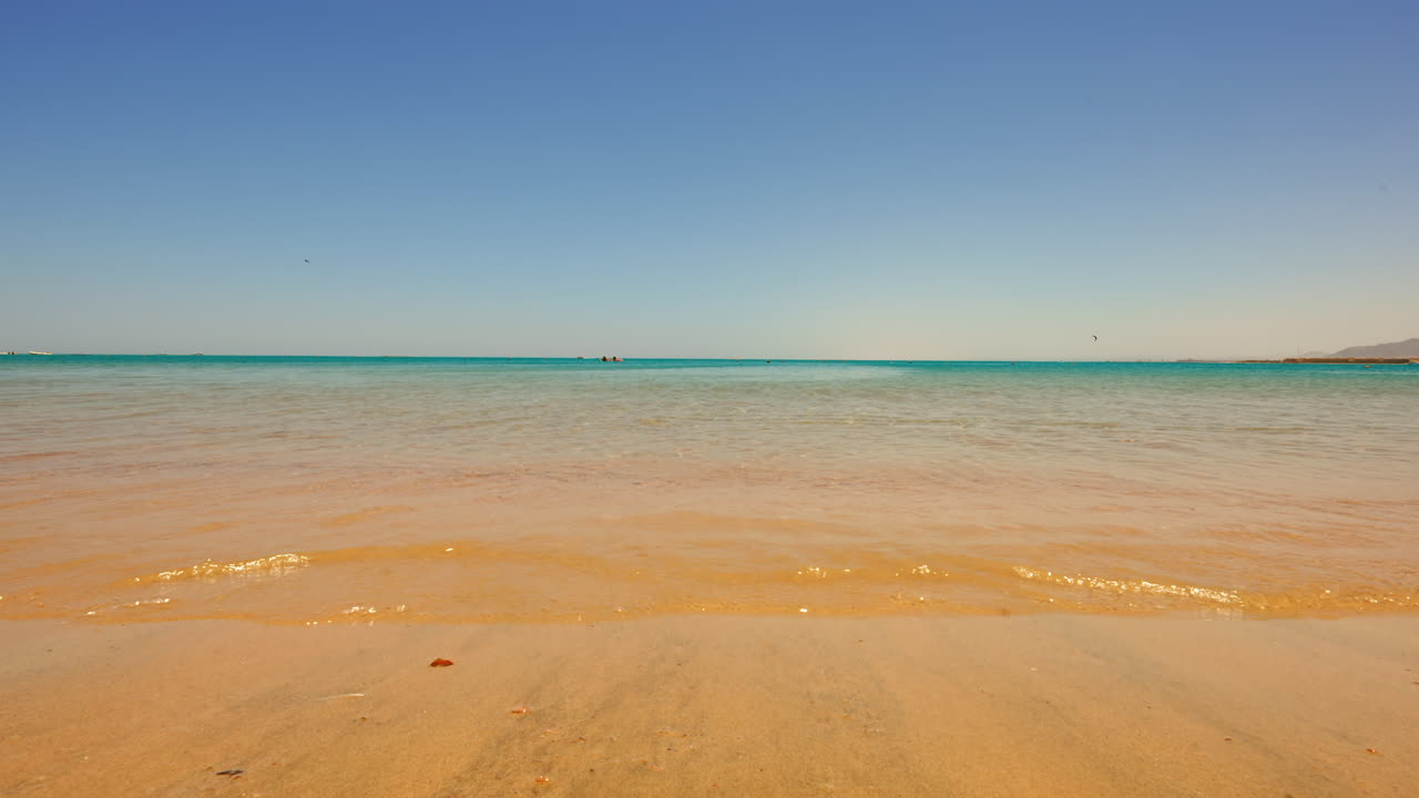 이집트 후르가다의 황금빛 모래사장 위로 잔잔한 파도