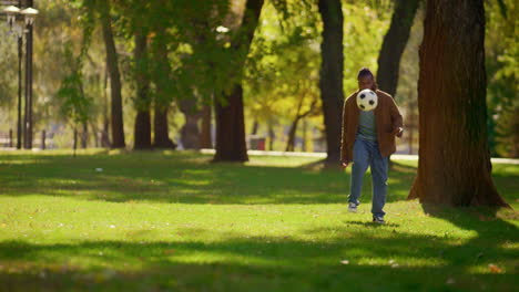 Glücklicher-Vater,-Der-Allein-Im-Sonnigen-Park-Fußball-Spielt.-Lächelnder-Spieler,-Der-Spaß-Hat.