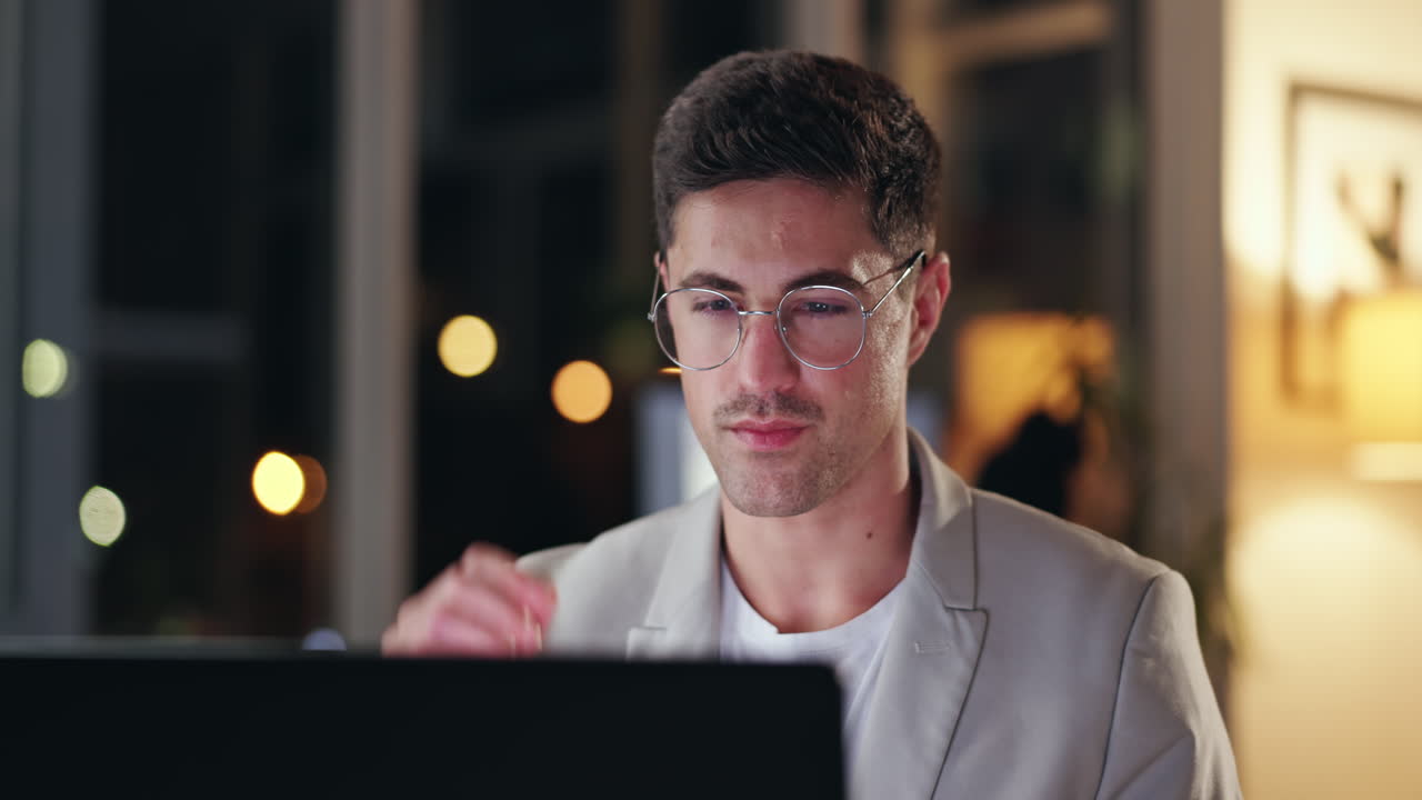 hombre trabajando en la computadora por la noche