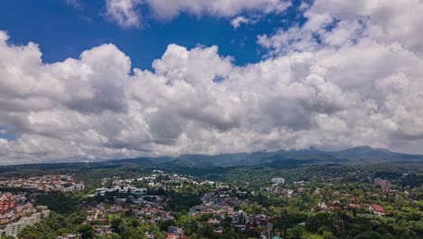 vista aérea de drones de nubes rodando sobre la ciudad de cuernavaca, en un día parcialmente soleado, en morelos, méxico, américa - seguimiento, tiro de hiperlapso