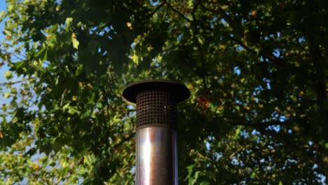 chimenea metálica con vapor y calor expulsado bajo el dosel del bosque