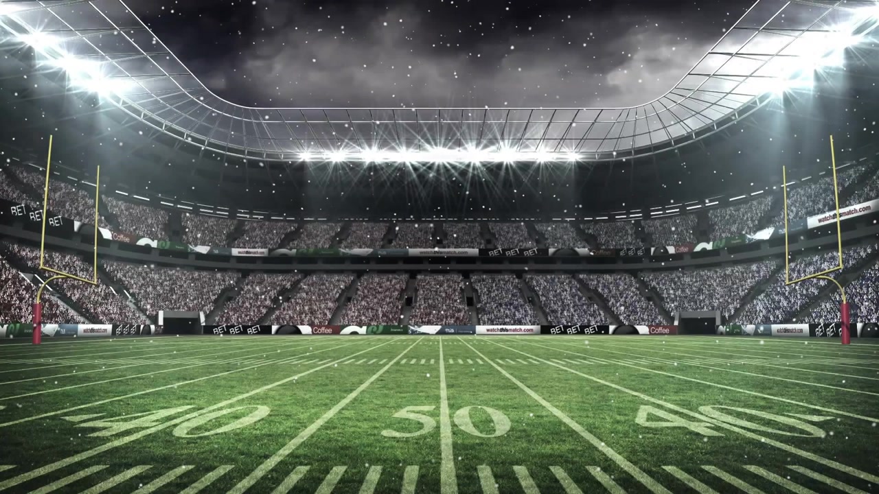 Opening aerial shot showing 50-yard stadium under light snow camera holding steady for wintry mood
