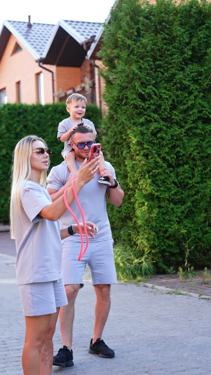 Family fun in summer sun. A family engages in a joyful moment outside, with a child on a father's shoulders, capturing memories together