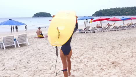 해변 에 서프보드 를 들고 있는 여자