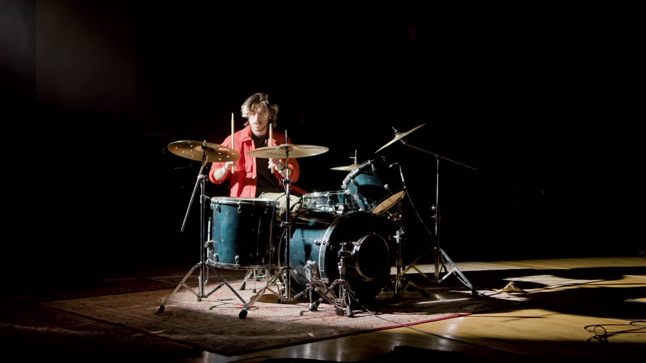 joven baterista tocando la batería en un estudio de música