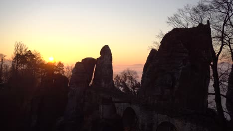 pan of famous bastei bridge during sunrise in national park of saxon switzerland