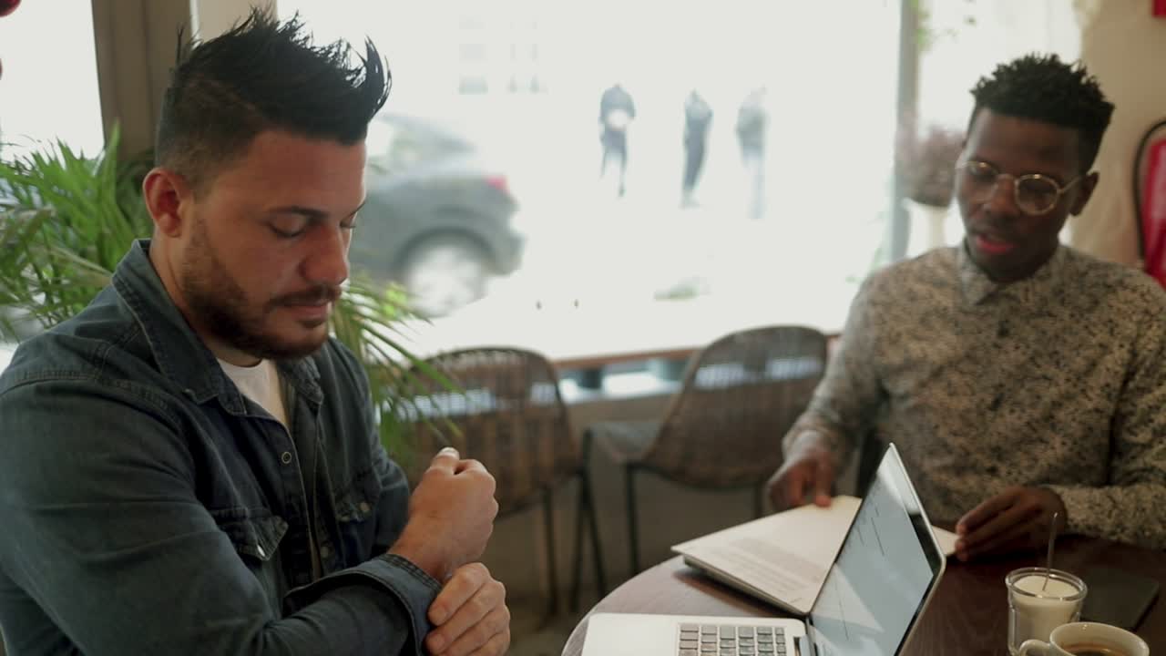 Freelance multietnici seri che discutono di lavoro in un caffè