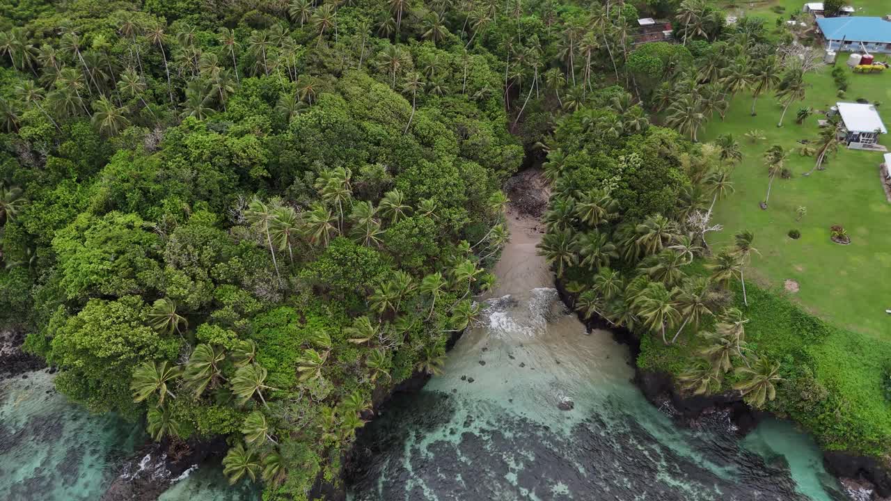 Stunning drone shot of a hidden cove in Samoa, where dense tropical rainforest meets the calm, transparent waters of a secluded bay in the South Pacific