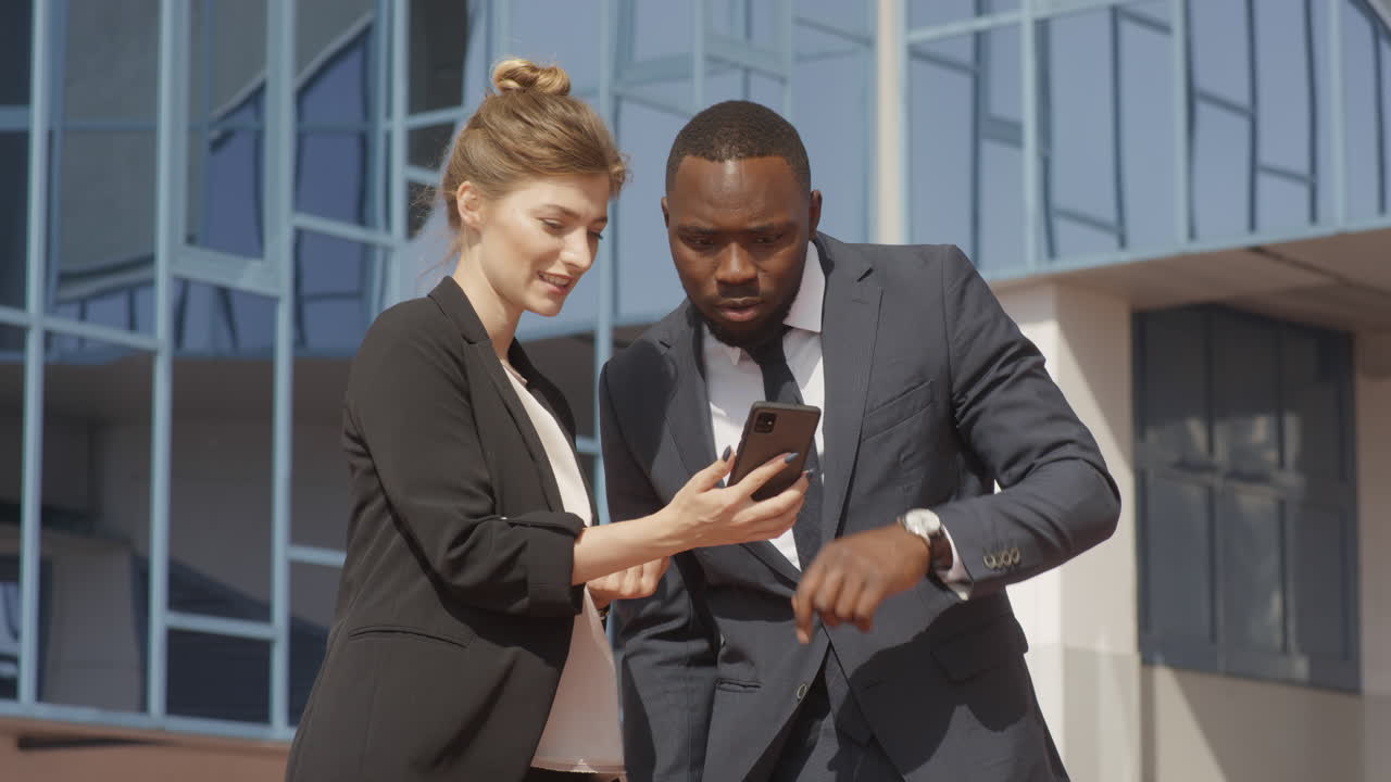 Business Couple Using Smartphone Near Office