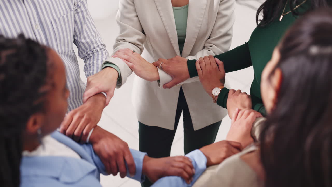 A diverse group of people showing teamwork and unity by linking arms