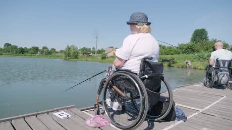 man with disabilities fishing at a lake. wheelchair. summertime. disabled person fishing