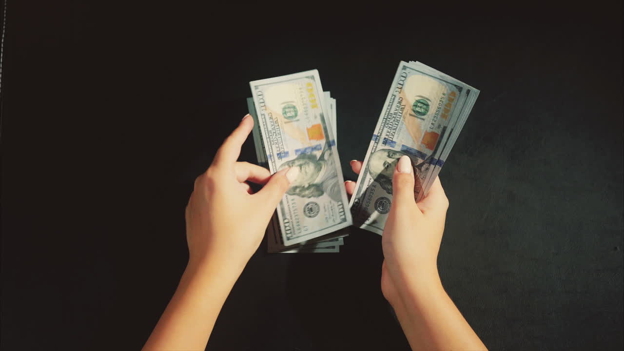 manos contando dólares