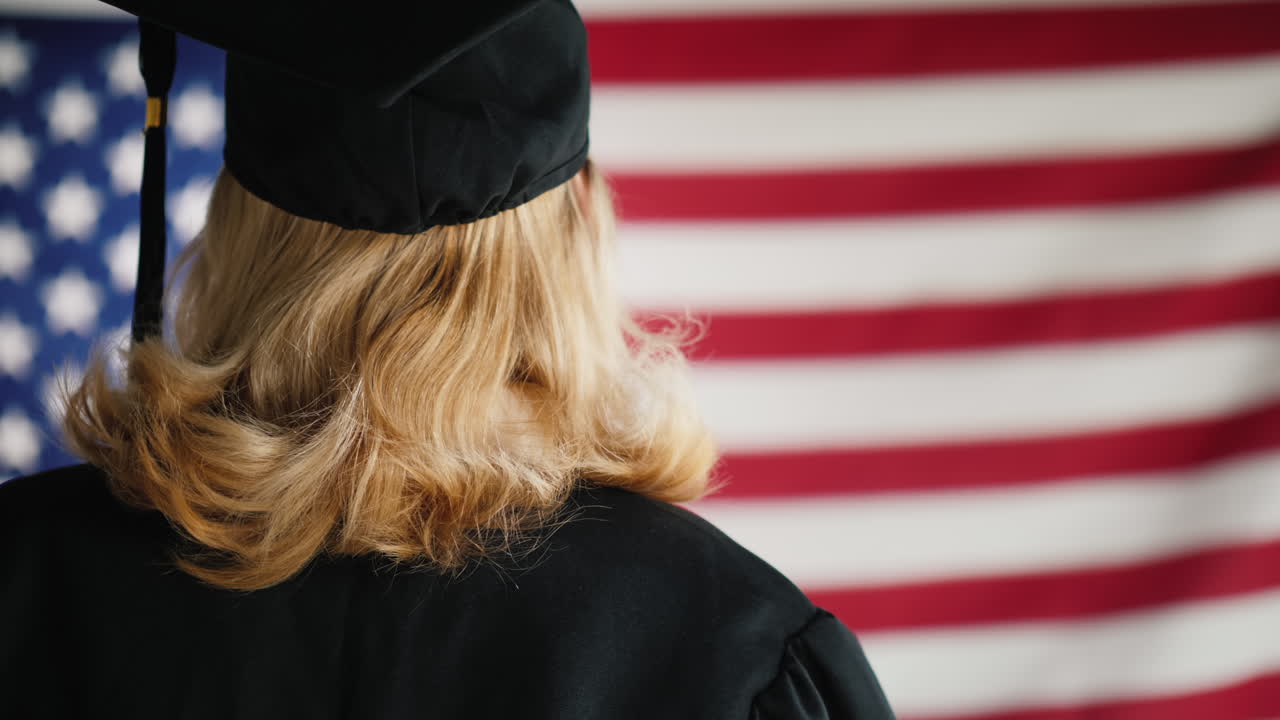 Absolvent s diplomem na pozadí americké vlajky