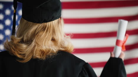 Graduieren-Mit-Einem-Diplom-Vor-Dem-Hintergrund-Der-Us-flagge