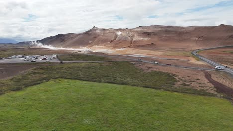 panoramic view of hverarönd geothermal area with green fields and parked campers