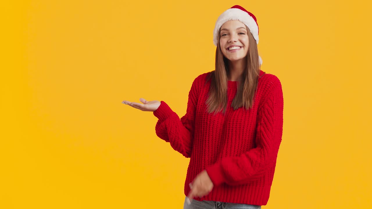mujer con sombrero de papá noel y suéter rojo presentando