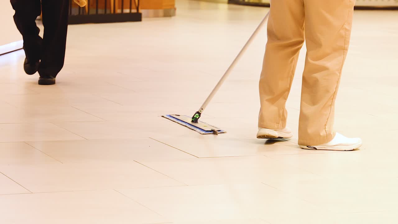 persona limpiando el suelo en un área ocupada