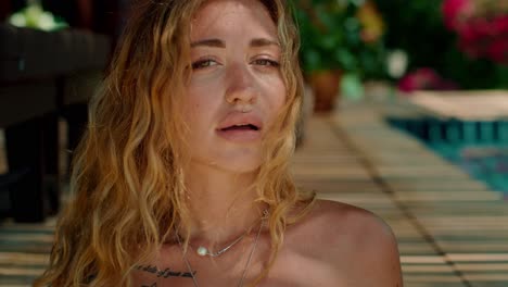 una mujer relajándose junto a la piscina.