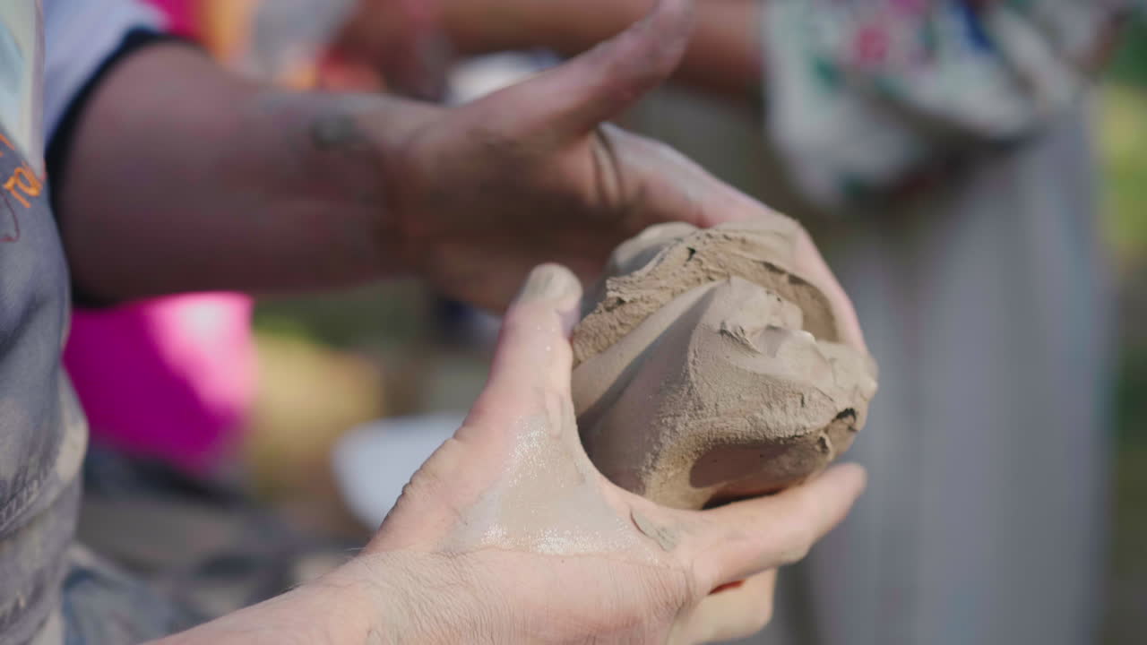 마스터 포터는 야외 박람회 클로즈업 4k 슬로우 모션에서 요리를 모델링하기 위해 점토 조각을 걸었습니다.