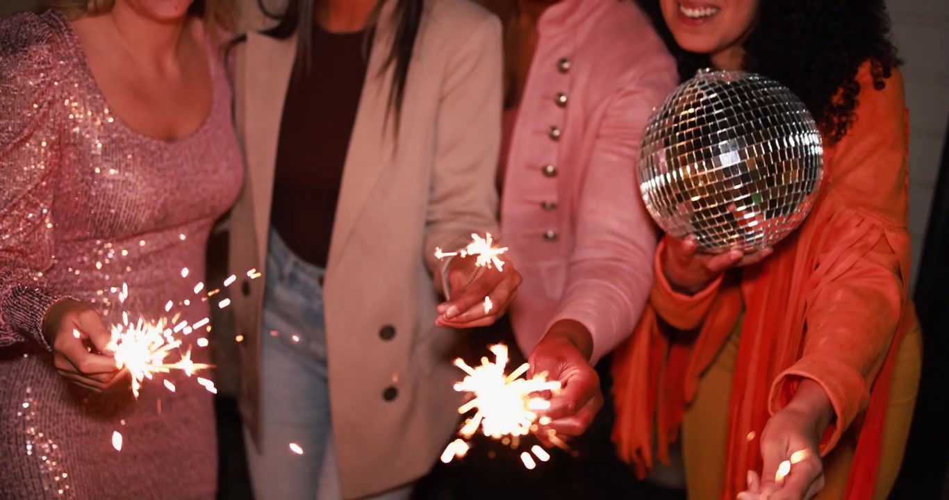 Amici felici che festeggiano con stelle filanti e una palla da discoteca a una festa