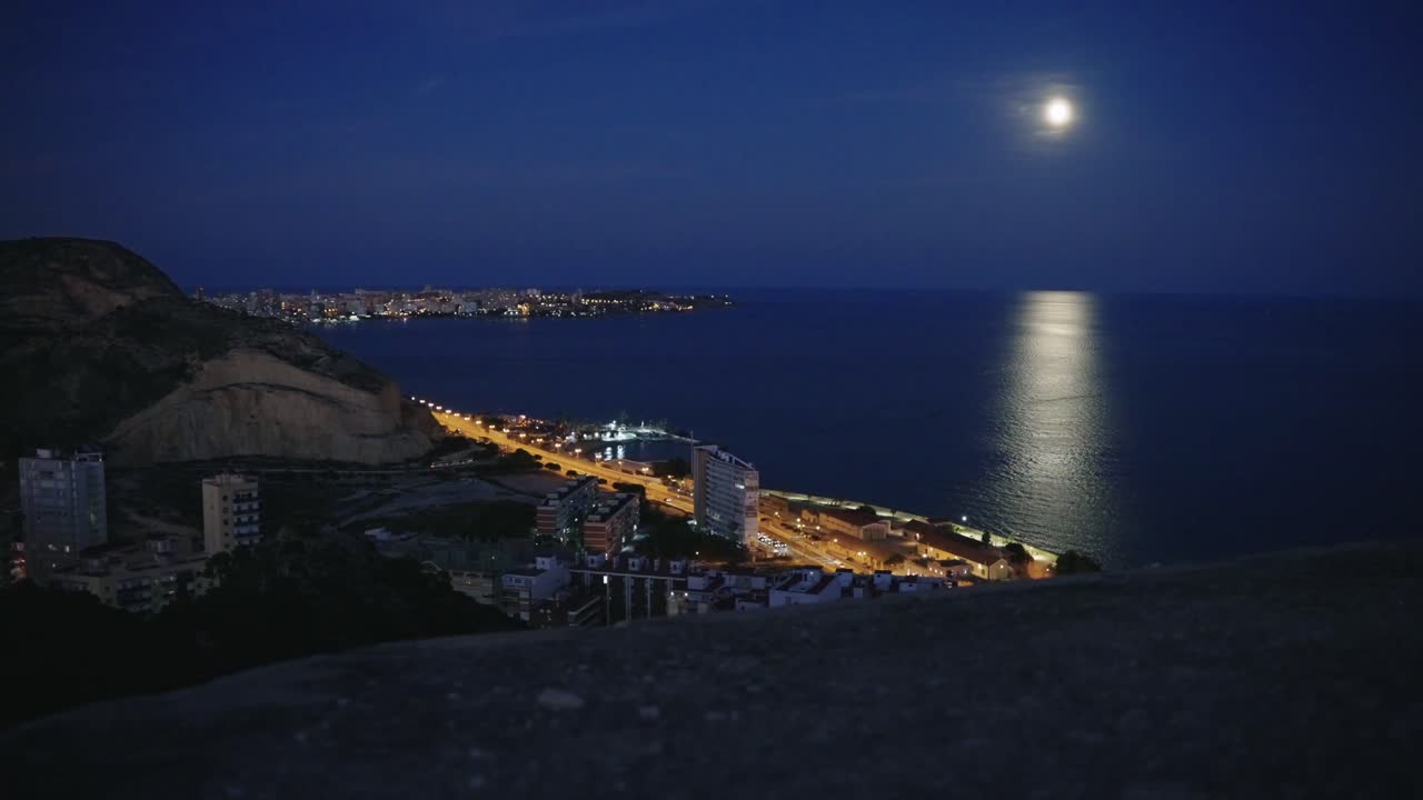 Alicante's coast at night seen from the top of the Castle Santa Barbara with moon, Spain