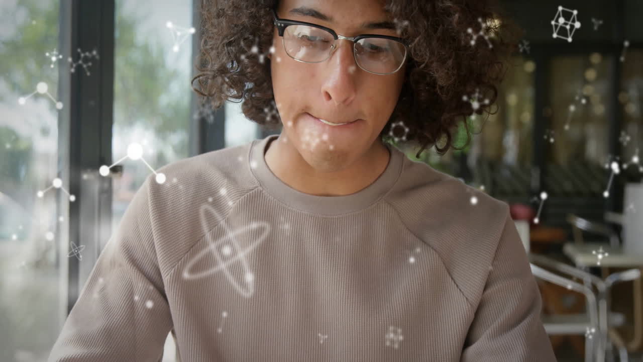 Adult man with glasses studying science at café table, showing floating molecular diagram graphics