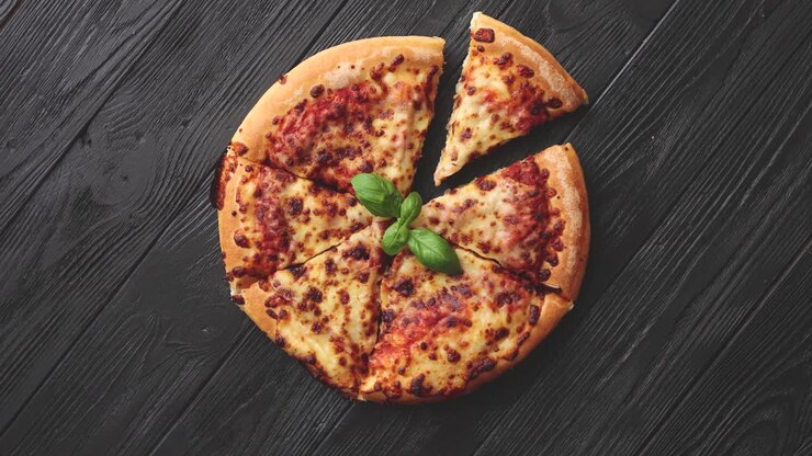 Pizza Margherita a fette con foglie di basilico