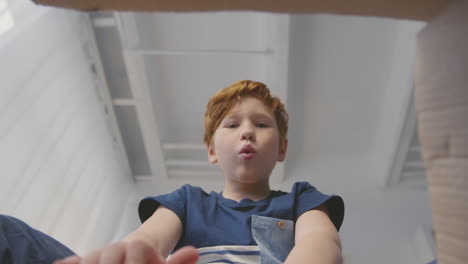 niño abriendo una caja de regalos