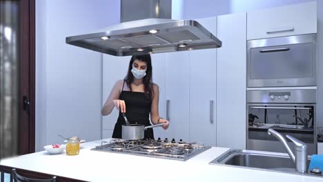 young woman at home preparing food with protective mask