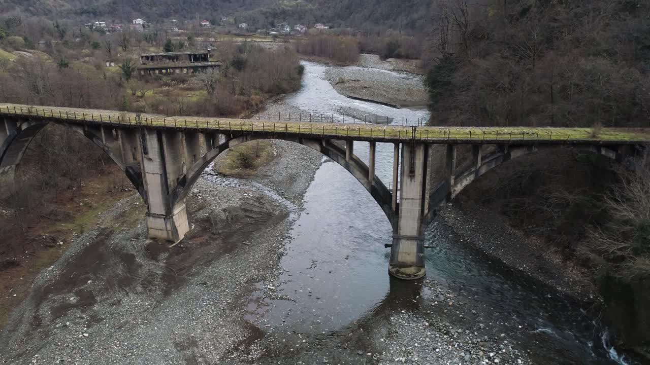 산악 지형 에 있는 강 을 가로지르는 오래된 콘크리트 아치 다리