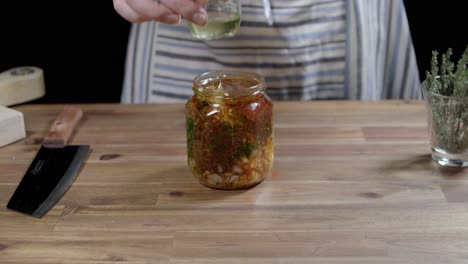 Chef-adds-oil-to-a-glass-container-to-prepare-chimichurri-sauce,-the-perfect-sauce-for-argentine-barbecues