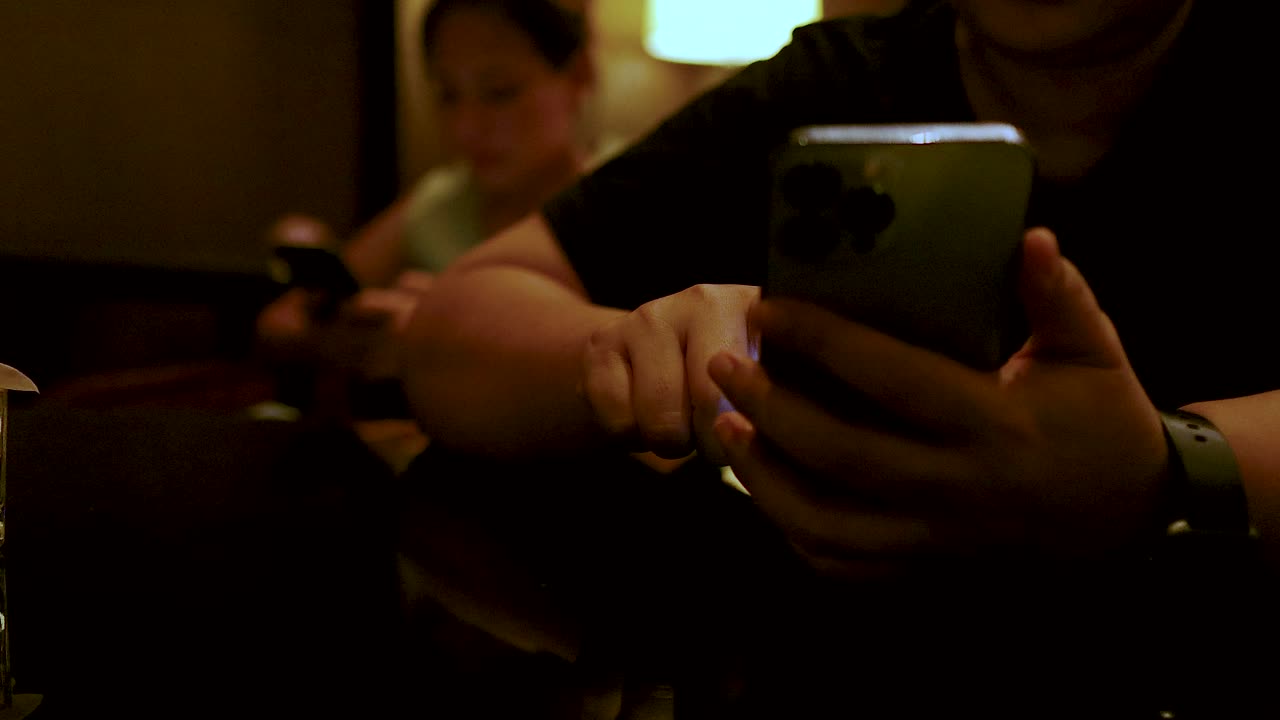 Two individuals focused on their smartphones