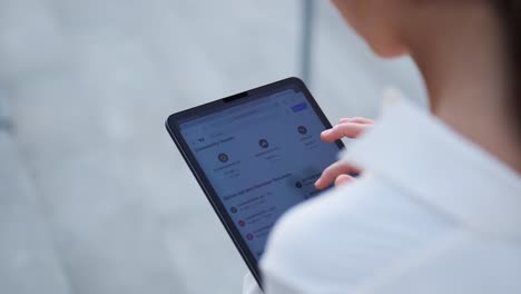 over-the-shoulder shot of a businesswoman browsing on her tablet